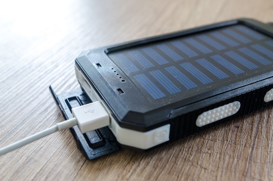 Moderne Solar-Powerbank im Einsatz zur Energieversorgung von Geräten im Garten.